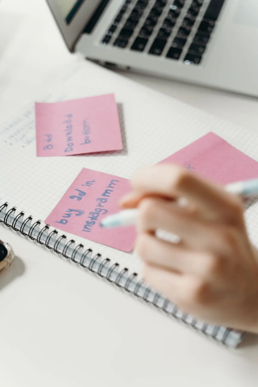 Hand writing ideas on colorful sticky notes during a brainstorming session