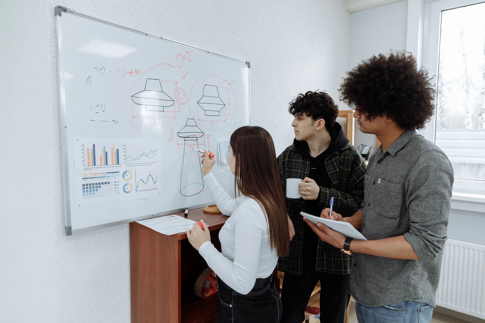 Design team sketching a product prototype on a whiteboard